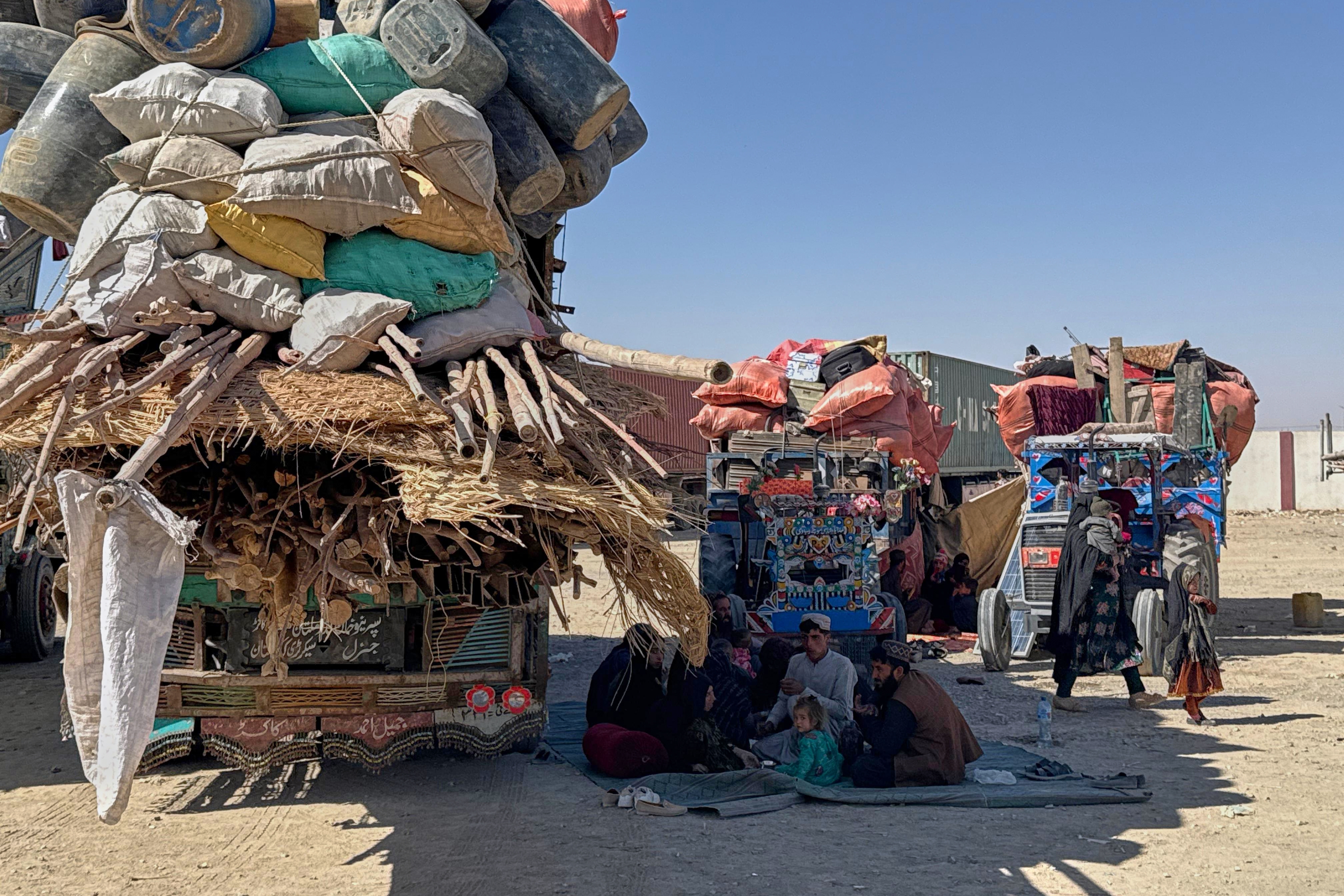 Afghan refugees sit next to their belongings loaded onto vehicles as they wait for opening of the border crossing point, which closed following Afghan and Pakistani security forces exchanged cross border firing, at a camp in Chaman, Pakistan, Sunday, Oct. 12, 2025.
